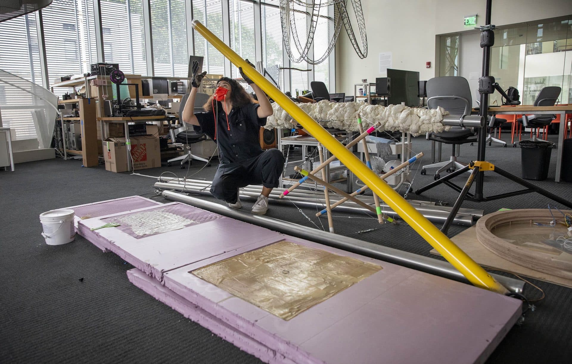 Artist Nicole L'Huillier looking over the unassembled elements of her installation "Membranas." (Robin Lubbock/WBUR)