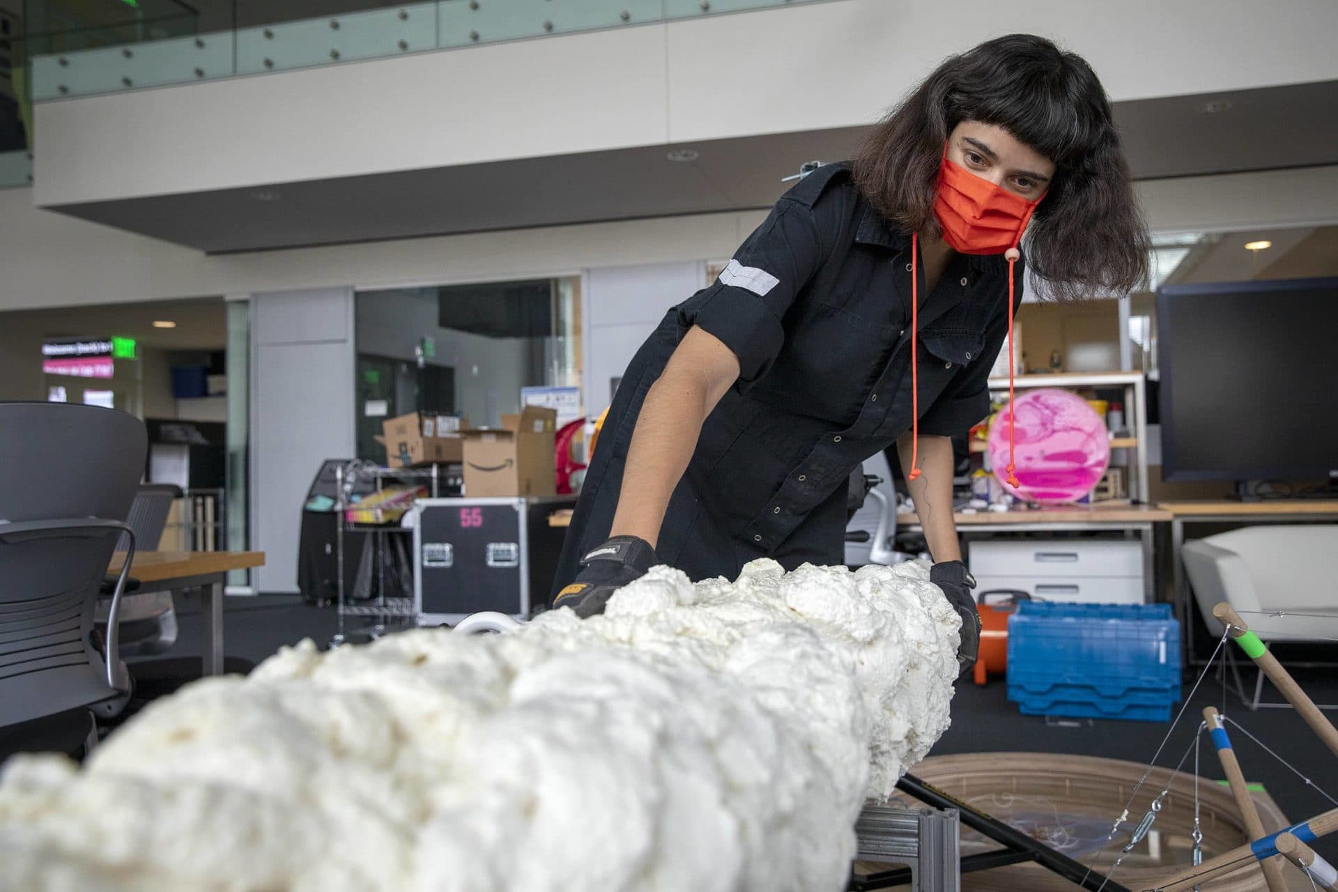 Artist Nicole L'Huillier looking over the unassembled elements of her installation "Membranas." (Robin Lubbock/WBUR)
