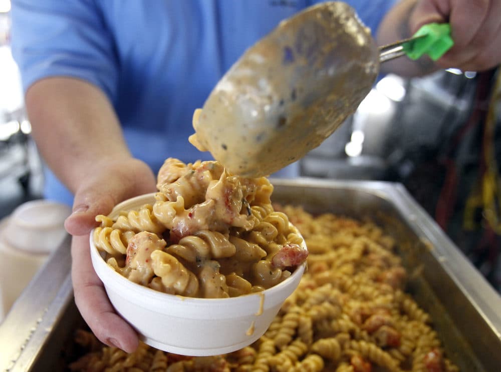Justin Anderson scoops a helping of Crawfish Monica into a bowl before serving it at the New Orleans Jazz and Heritage Festival in New Orleans, Sunday, May 8, 2011. (Patrick Semansky/AP)