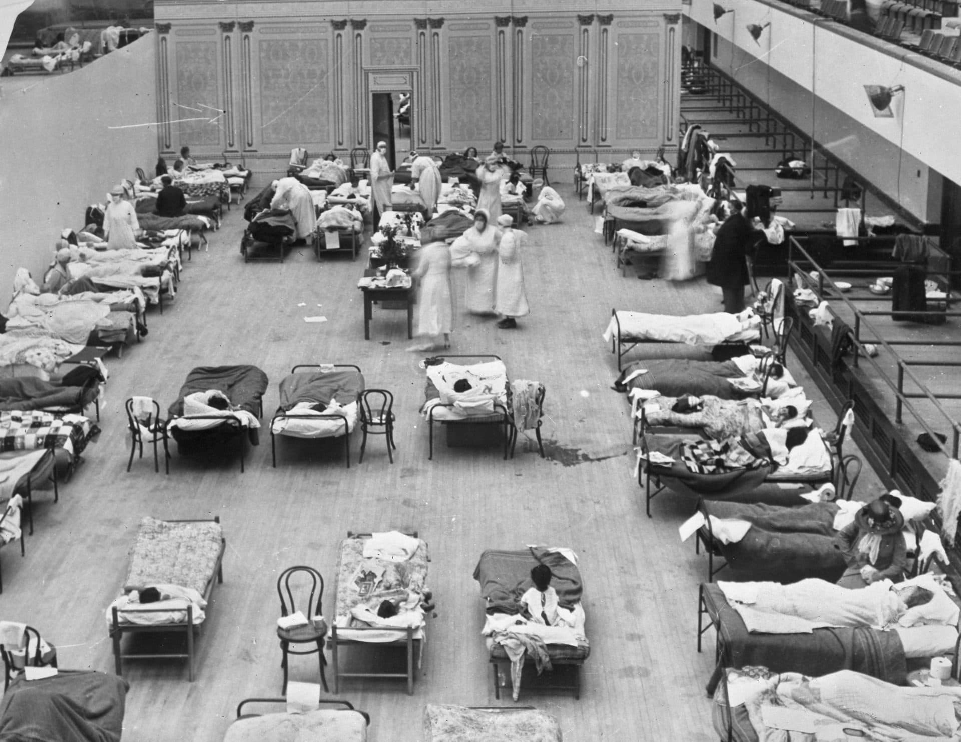 Volunteer nurses from the American Red Cross tend to influenza patients in the Oakland Municipal Auditorium, used as a temporary hospital in 1918-1919. (Edward A. "Doc" Rogers/Library of Congress via AP)