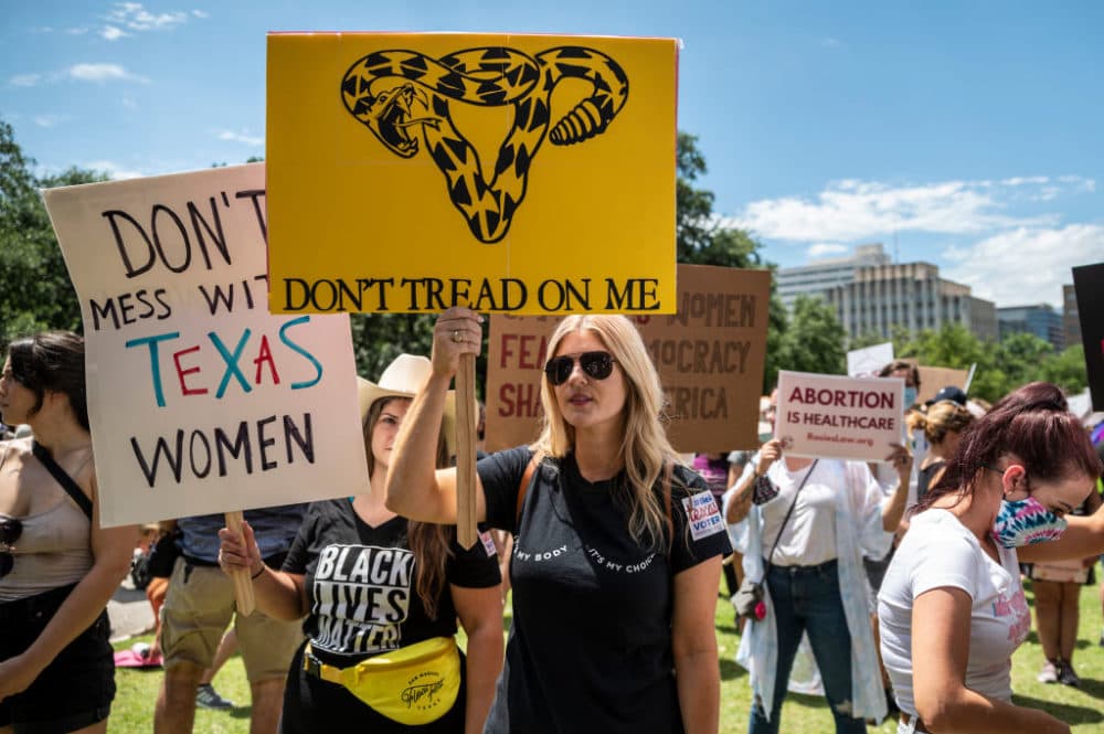 Protesters hold up signs at a protest outside the Texas state capitol on May 29, 2021 in Austin, Texas. (Sergio Flores/Getty Images)