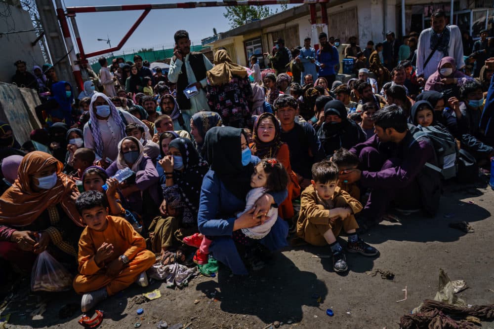 KABUL, AFGHANISTAN -- AUGUST 25, 2021: Women and children are made to crouch and wait outside the Taliban controlled check point near the Abbey Gate, before making their way towards the British military controlled entrance of the airport, in Kabul, Afghanistan, Wednesday, Aug. 25, 2021. (MARCUS YAM / LOS ANGELES TIMES)