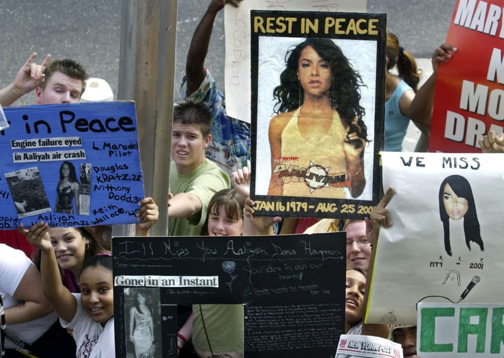 Fans holds signs in memory of actress and R&B singer Aaliyah during TRL outside of the MTV studios in New York City on Aug 28, 2001. (Scott Gries/Getty Images)