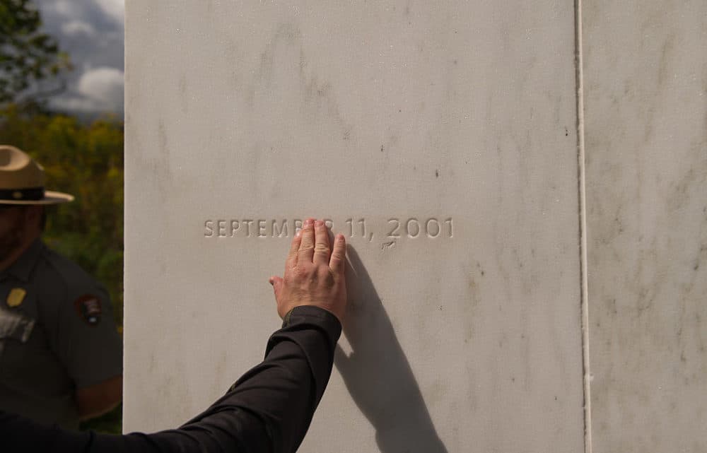 A visitor traces the date etched in a marble slab on the Wall of Names at the Flight 93 National Memorial in Shanksville, Pa., in 2016. United Airlines Flight 93 crashed into a field outside Shanksville, Pa., with 40 passengers and four hijackers aboard on Sept. 11, 2001. (Jeff Swensen/Getty Images)