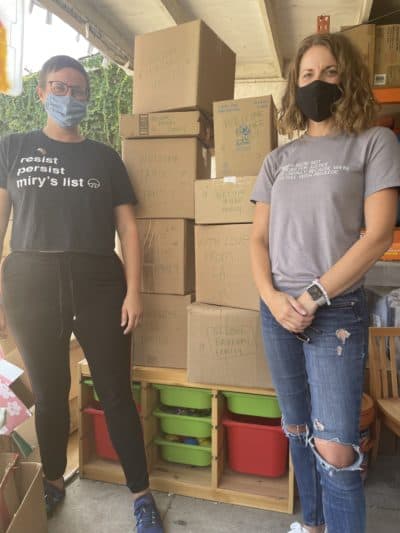 Miry's List founder Miry Whitehill and volunteer Krysta Masciale in front of the care packages they've assembled for new Afghan refugees arriving in the U.S. (Tonya Mosley/Here & Now)