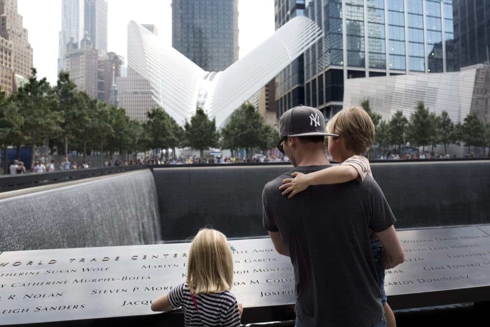 Mikal Petersen and his children, Elle, 7, and Jude, 4, looked at the North Pool of the National September 11 Memorial on Sept. 5, 2017, in New York. "I tell them this represents a building that once stood here, where many people lost their lives, and that now it is a sacred spot," said Petersen. (Mark Lennihan/AP)