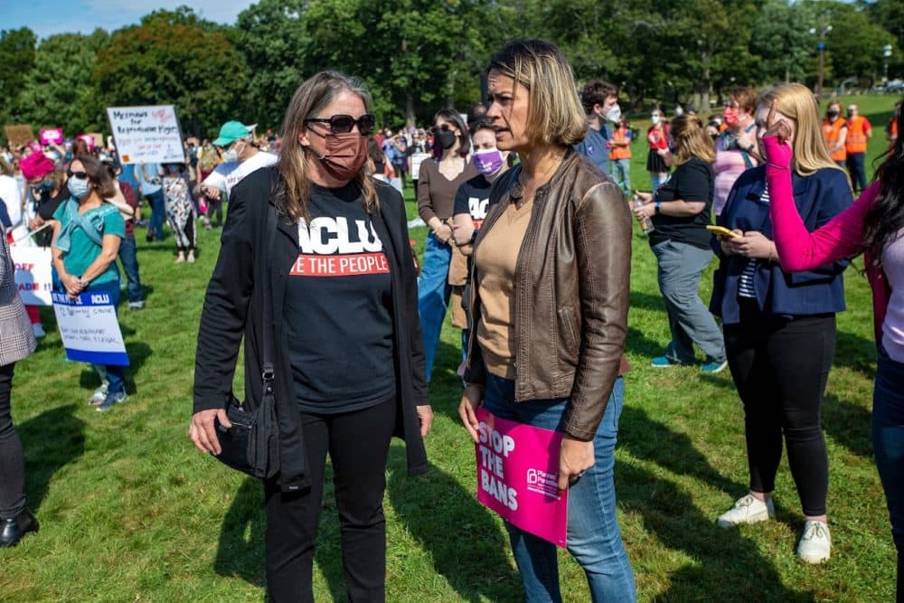 ACLU Director Carol Rose and City Councilor Annissa Essaibi George speak to each other during the Boston Rally to Defend Abortion at. the Franklin Park Playstead where at least 1000 people gathered to rally as part of nationwide protests happening to defend abortion rights. (Jesse Costa/WBUR)