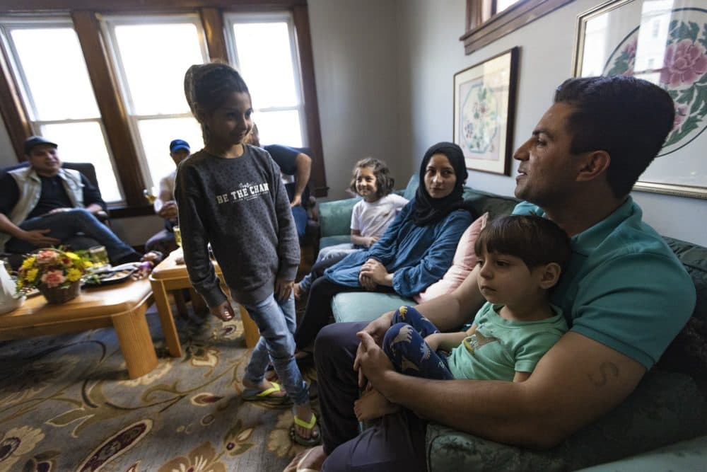 The Atayi family gathers with cousins and new friends two days after moving into their apartment in Worcester. They fled Afghanistan after the Taliban took control. (Jesse Costa/WBUR)