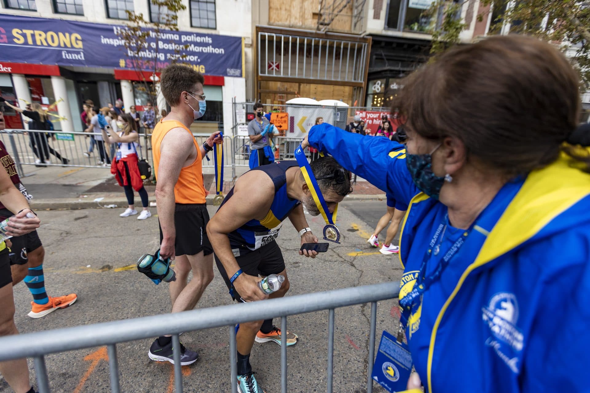 Carlos Velez of San Antonio receives his medal for finishing the Boston Marathon. (Jesse Costa/WBUR)