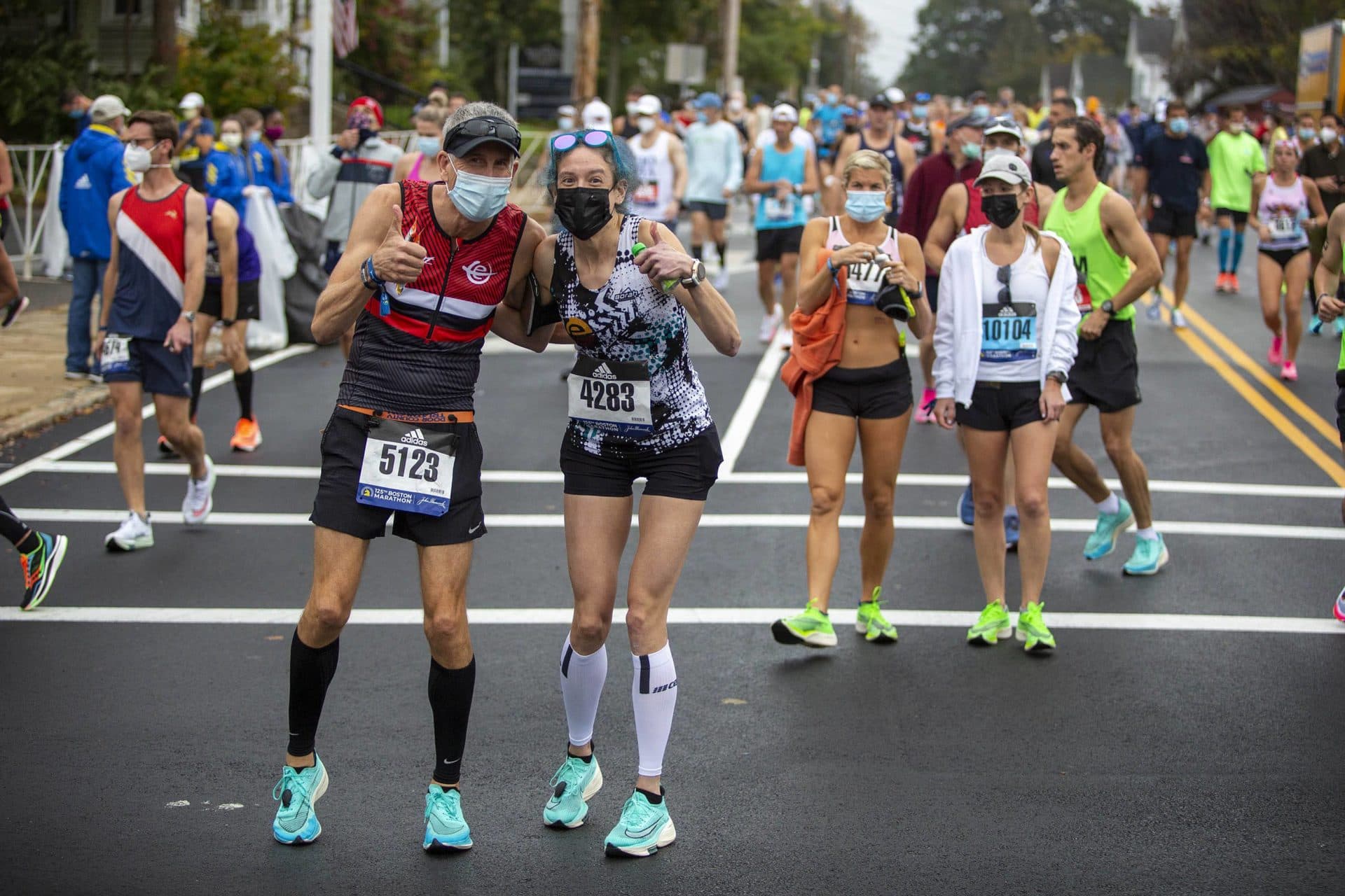 Dave Marsalli and Jessi Crane pause in Hopkinton for a photograph as they make their way to the start line. (Robin Lubbock/WBUR)