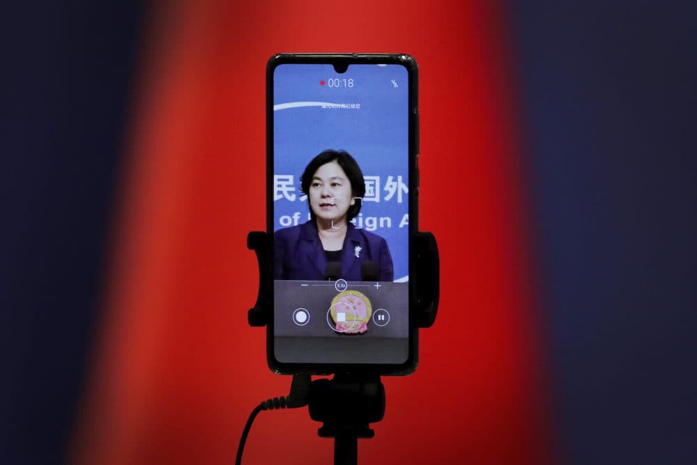 A smartphone records Chinese Foreign Ministry spokeswoman Hua Chunying as she speaks during a daily briefing at the Ministry of Foreign Affairs in Beijing. "I'd like to stress that if the United States truly respects facts, it should open the biological lab at Fort Detrick, give more transparency to issues like its 200-plus overseas bio-labs, invite WHO experts to conduct origin-tracing in the United States," she said at a January 2021 MOFA press conference that went viral in China. (Andy Wong/AP)