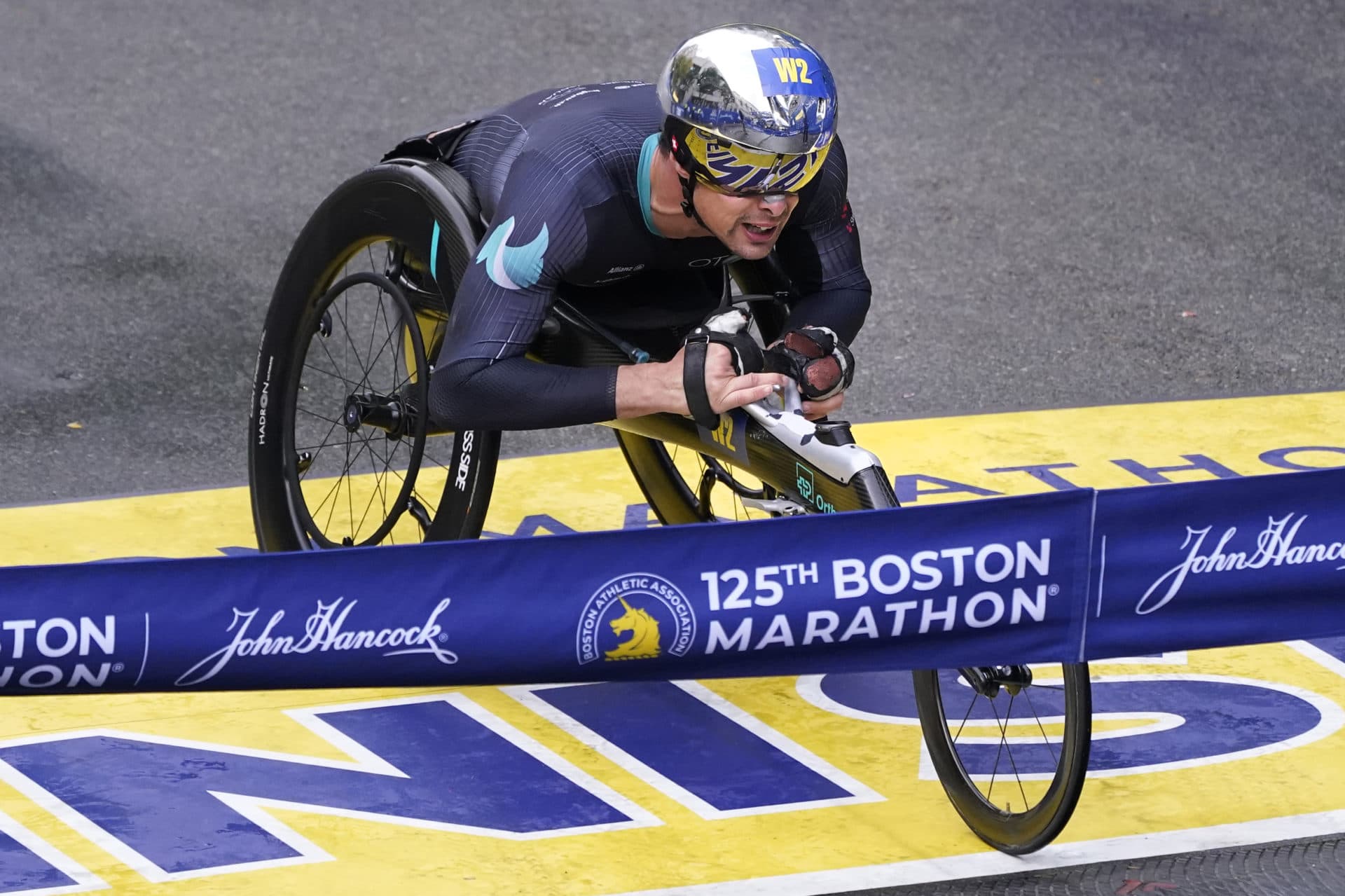 Marcel Hug, of Switzerland, rolls across the finish line to win the men's wheelchair division. (Charles Krupa/AP)