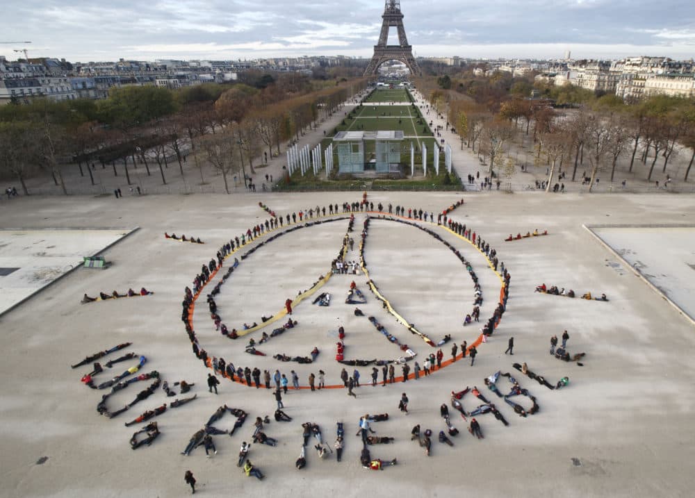 Dec. 6, 2015: Environmentalist activists form a human chain representing the peace sign and the spelling out "100% renewable" on the side line of the COP21, United Nations Climate Change Conference, near the Eiffel Tower in Paris. (Michel Euler/AP/File)