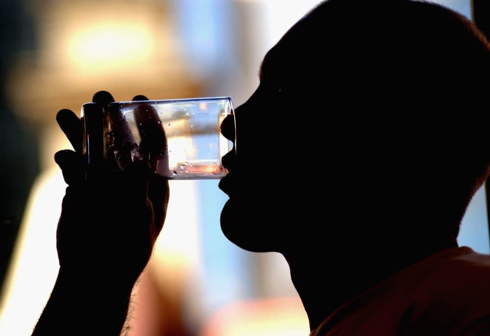 A man takes a drink of water. (Darren England/Getty Images).