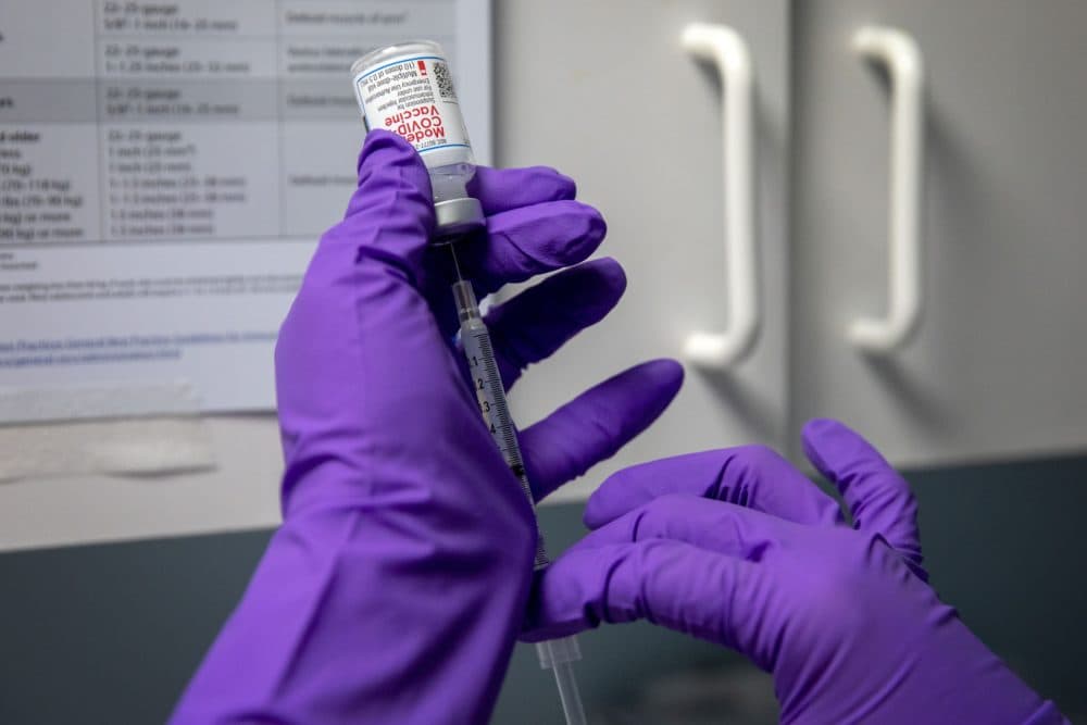 A COVID vaccination shot is prepared. (Robin Lubbock/WBUR)