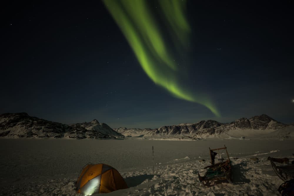 Aurora borealis over the remote East Coast of Greenland. Melting ice on the world's largest island is now contributing more to sea level rise than Antarctica and all the world’s glaciers combined. (Scott Badger)