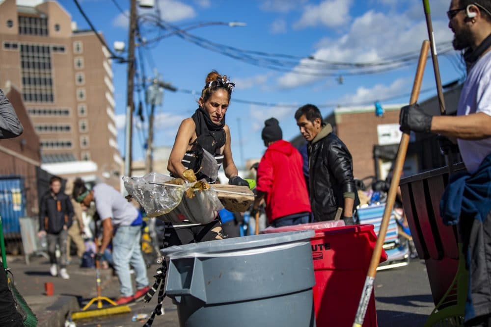 Boston Public Health Commission workers and shelter volunteers pick up trash after clearing out tents of people living on Atkinson Street. (Jesse Costa/WBUR)