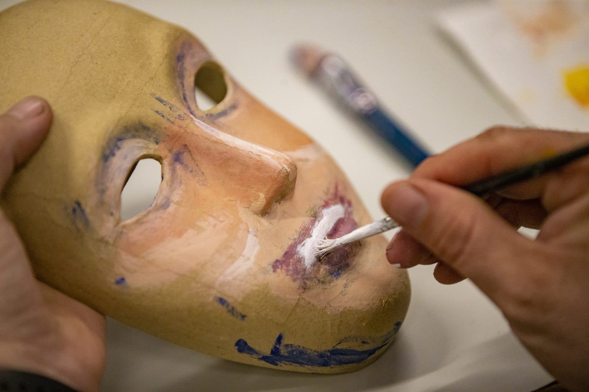 Hicks paints the outside of his mask. (Jesse Costa/WBUR)