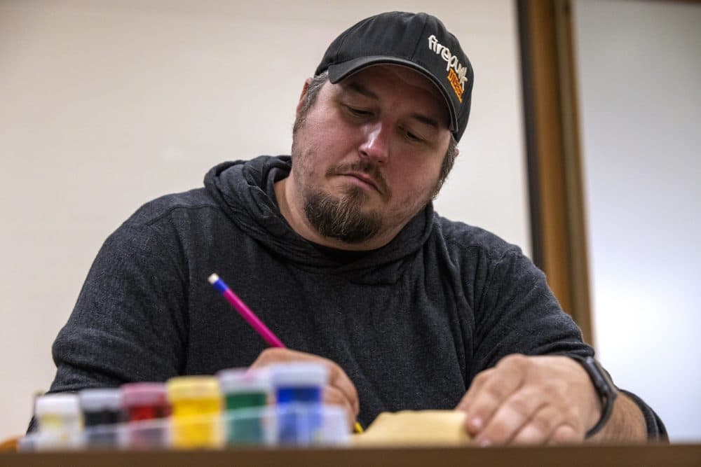 Air Force veteran John Hicks works on a mask he made as part of art therapy at Home Base. (Jesse Costa/WBUR)