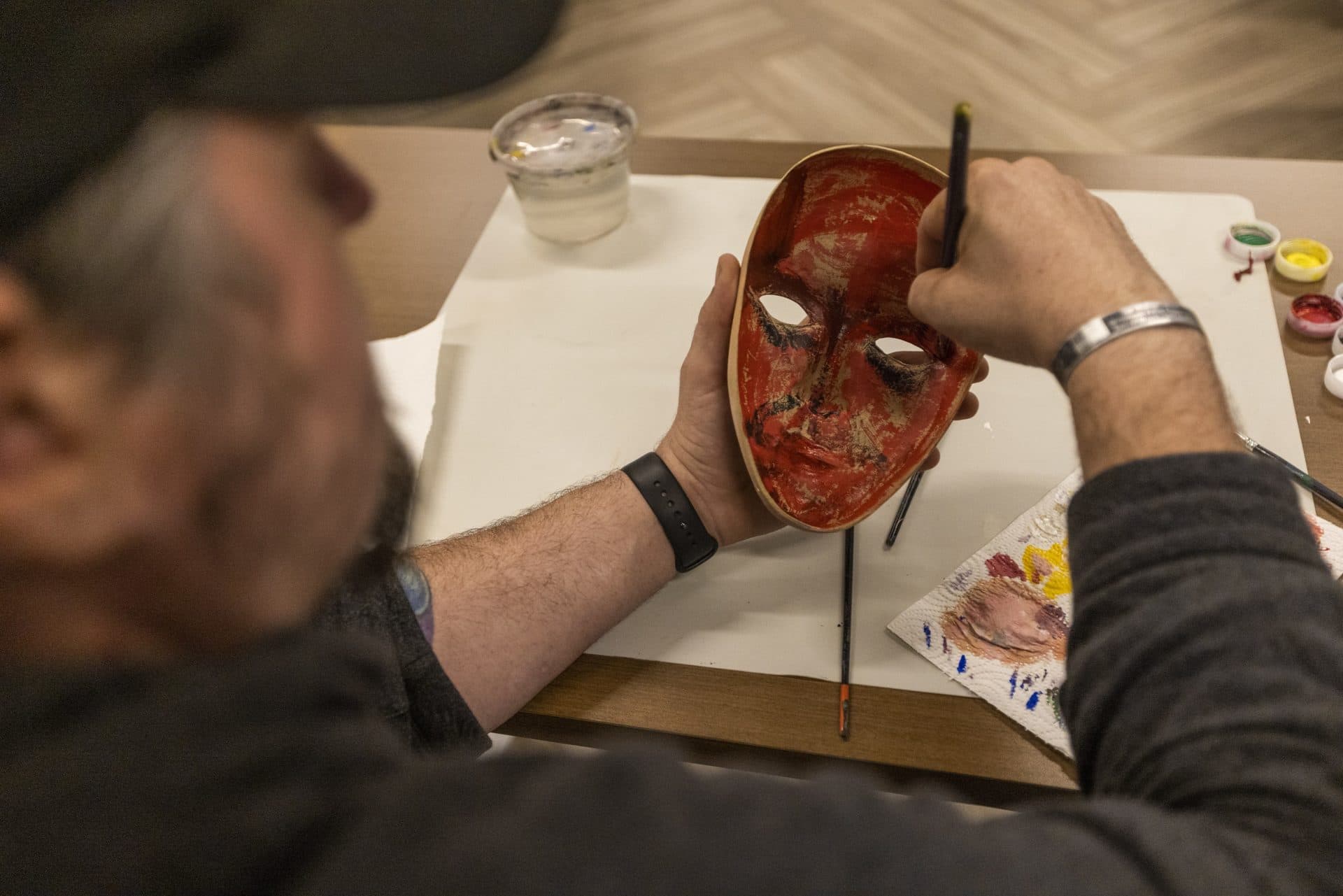 Air Force veteran John Hicks paints the inside of his mask. (Jesse Costa/WBUR)