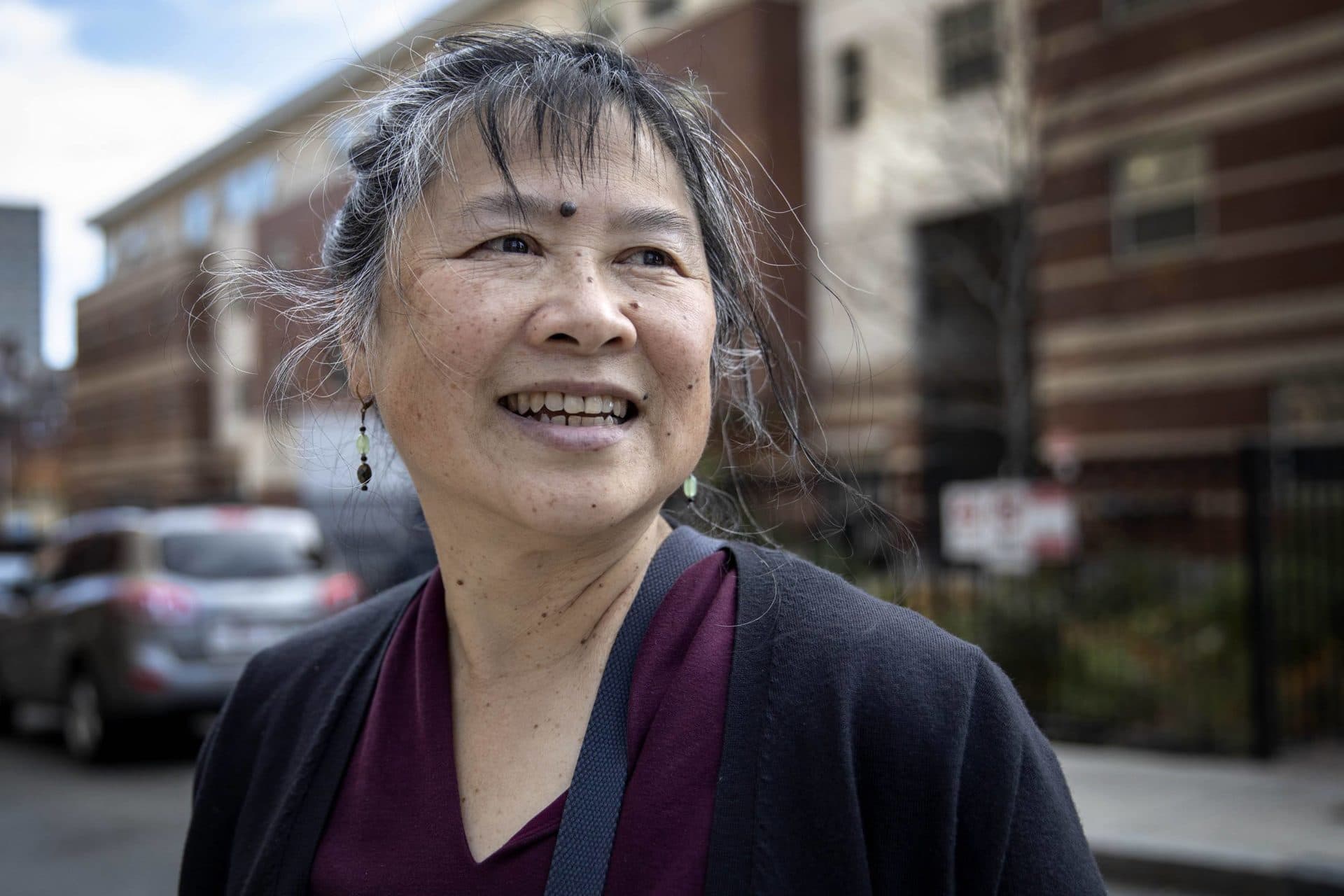 Lydia Lowe, the executive director of The Chinatown Community Land Trust, in front of Oak Terrace Apartments, which will be the first building in Chinatown with a microgrid. (Robin Lubbock/WBUR)