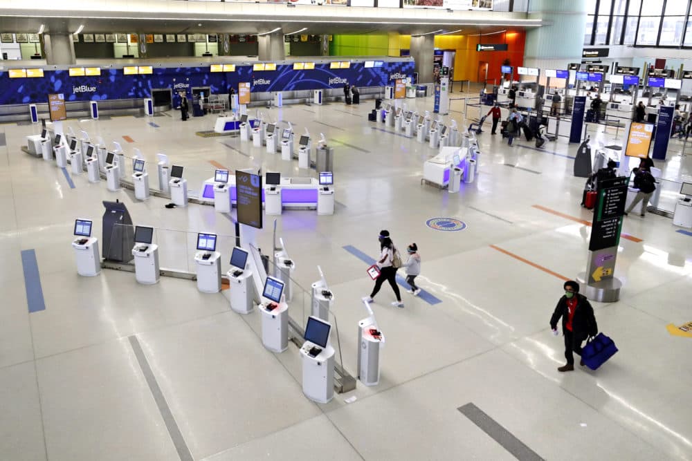 Travelers walk through the nearly empty JetBlue terminal at Logan Airport, Friday Nov. 20, 2020, in Boston. Crowds are expected to return this year for Thanksgiving. (Michael Dwyer/AP)