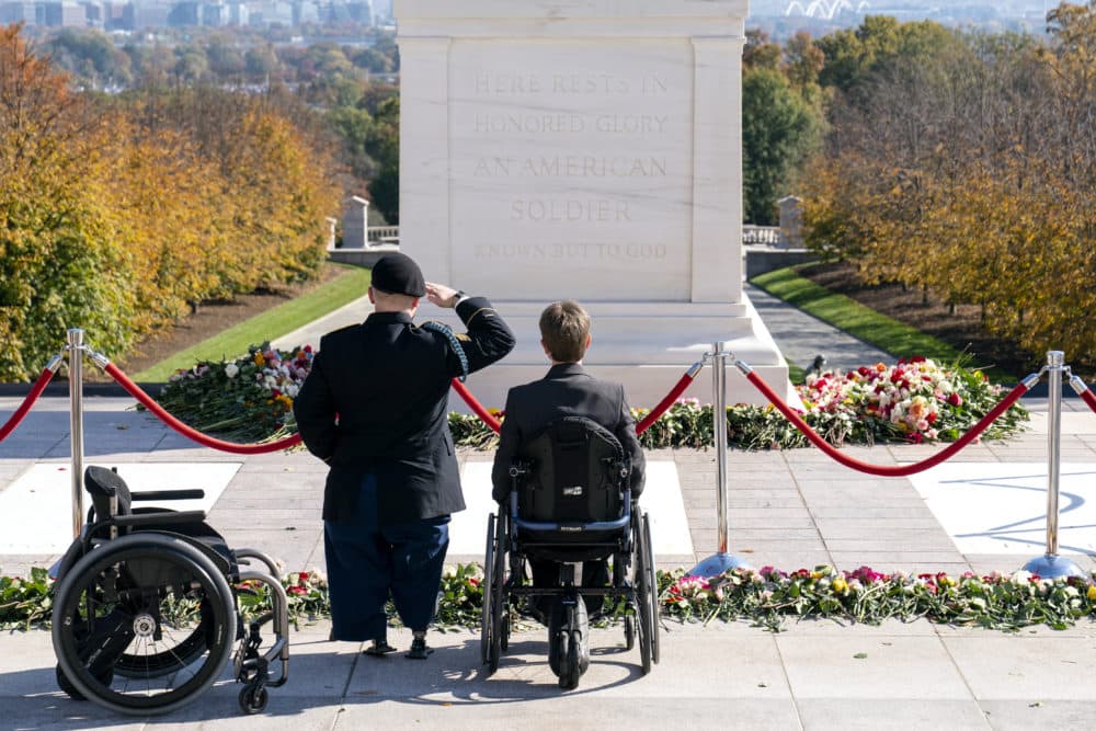 U.S. Army Sgt. Brian Pomerville (left) stands and salutes with his wife Tiffany Lee, both from Roanoke, Va., after placing flowers during a centennial commemoration event at the Tomb of the Unknown Soldier, in Arlington National Cemetery on Wednesday, Nov. 10, 2021, in Arlington, Va. (Alex Brandon/AP/Pool)
