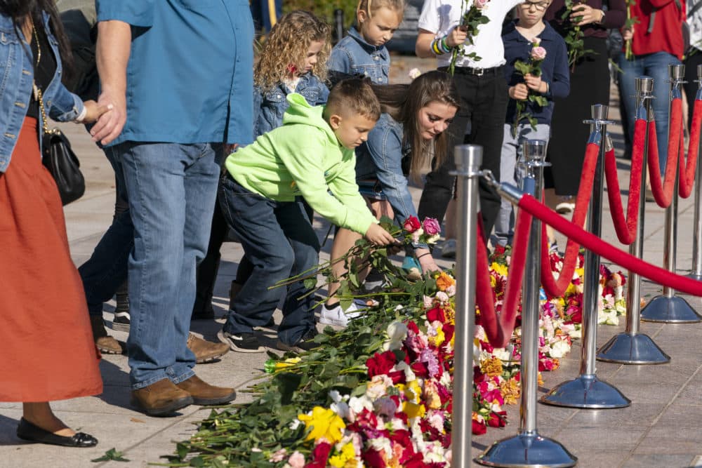 People place flowers during a centennial commemoration event at the Tomb of the Unknown Soldier, in Arlington National Cemetery, Wednesday, Nov. 10, 2021, in Arlington, Va. (Alex Brandon/AP/Pool)