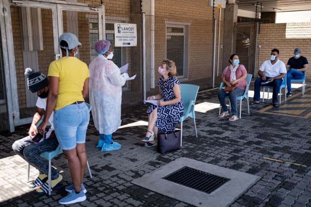 A health care worker speaks with a woman queuing for a PCR COVID-19 test in Johannesburg on Nov. 30, 2021. A new, heavily mutated COVID-19 variant named omicron spread across the globe on Sunday, shutting borders and renewing curbs. (Emmanuel Croset/AFP/Getty Images)
