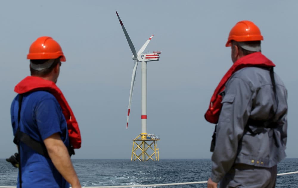 Workers look out at wind turbines at the Alpha Ventus offshore windpark on April 28, 2010 in the North Sea approximately 70km north of the German coast. (Sean Gallup/Getty Images)