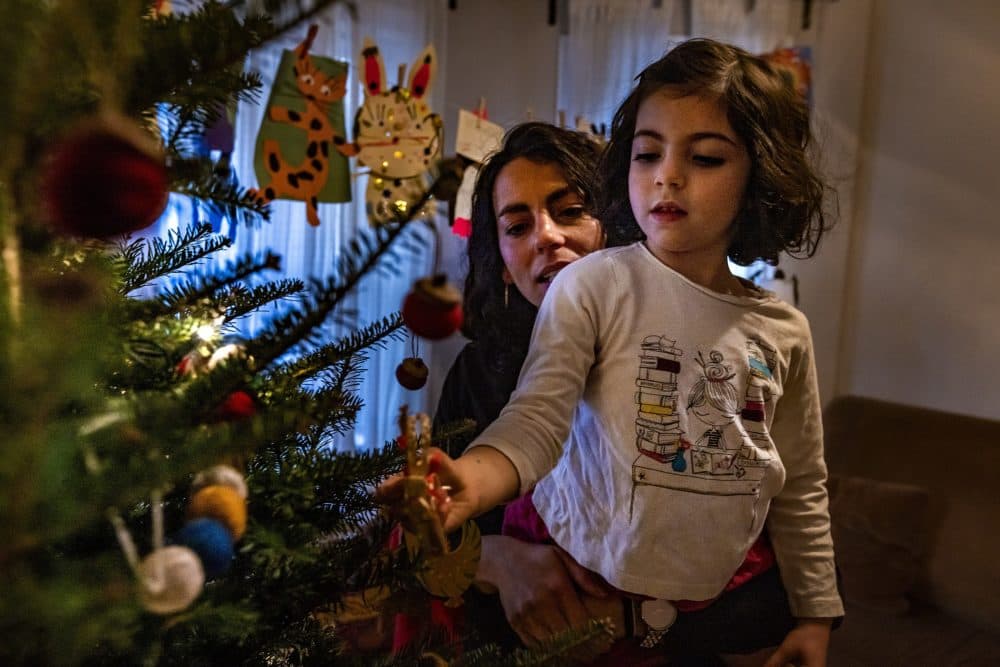 Mei Elensary and her 4-year-old daughter Mimi look at ornaments on their Christmas tree on a day Mimi will not attend school after an announcement was made one of her classmates tested positive with the COVID-19 virus. (Jesse Costa/WBUR)