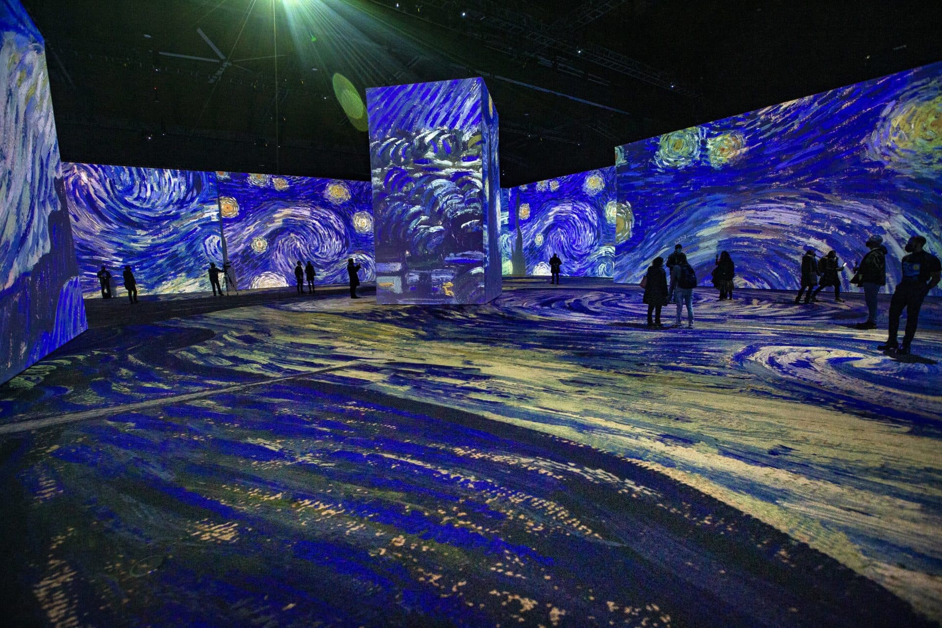 Projections of Vincent van Gogh’s "The Starry Night" flood the walls and floor and surround members of the media as they experience the press preview of “Imagine Van Gogh” at the SoWa Power Station in the South End. (Jesse Costa/WBUR)
