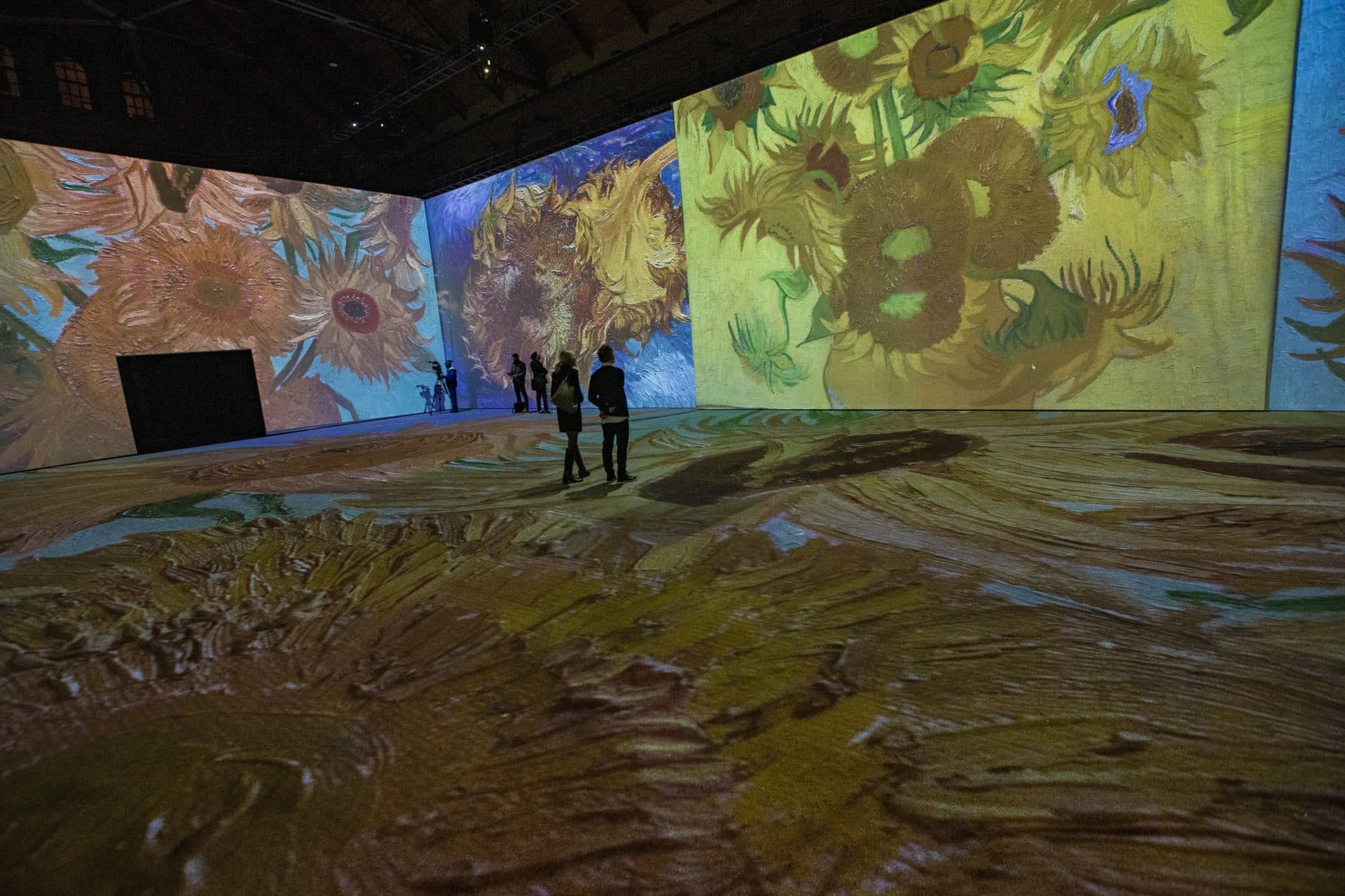 Vincent van Gogh’s "Sunflowers" projected onto the walls and floor during a press preview of "Imagine Van Gogh" at the SoWa Power Station in the South End. (Jesse Costa/WBUR)