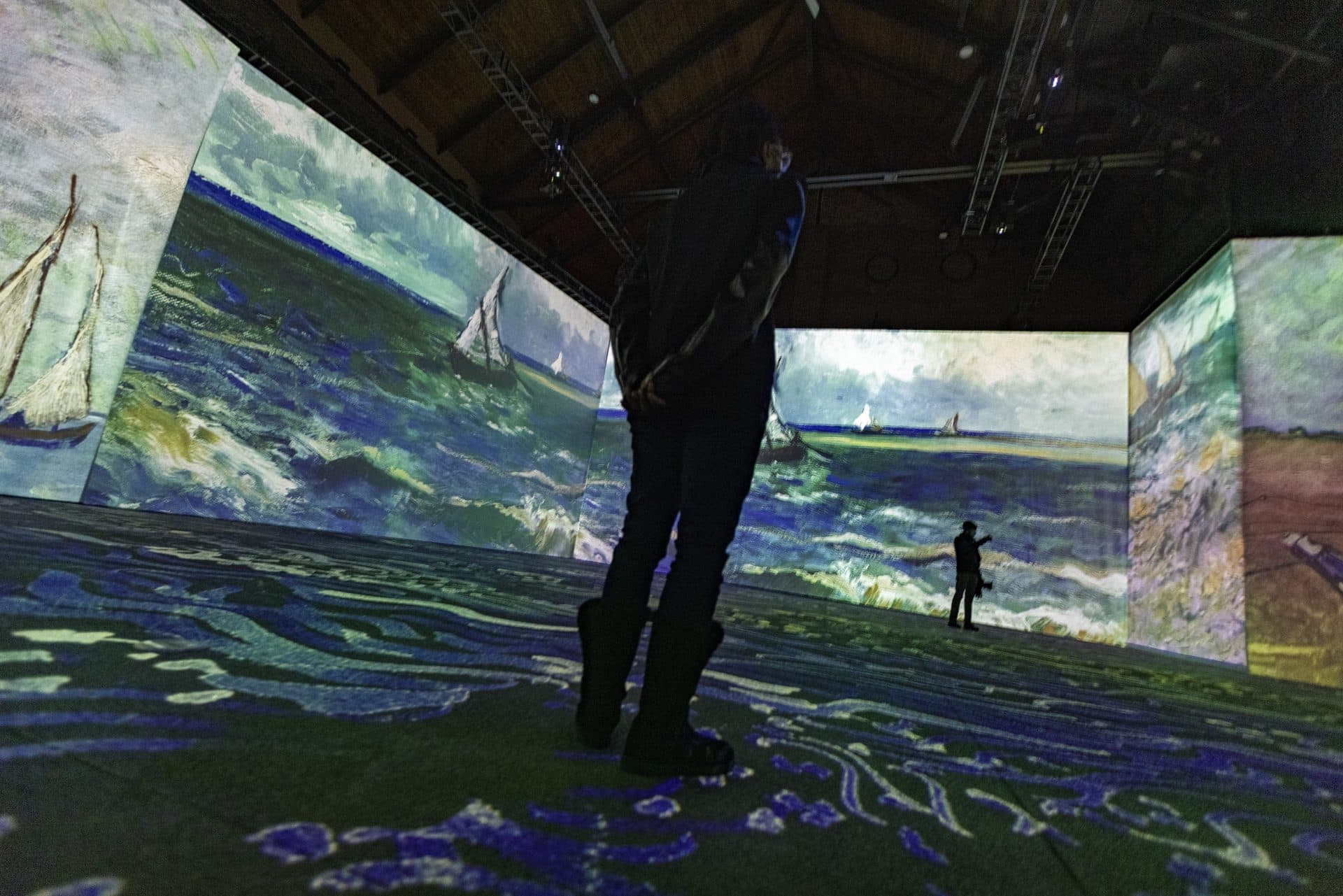 Vincent van Gogh’s “Seascape near Les Saintes-Maries-de-la-Mer” is projected onto the walls and floor during a press preview of “Imagine Van Gogh” at the SoWa Power Station in the South End. (Jesse Costa/WBUR)