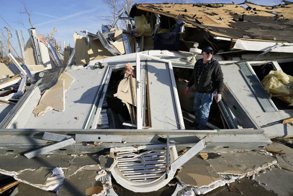 Kenny Sanford exits his mother-in-law's apartment through a collapsed wall Dec. 11, 2021, in Mayfield, Ky. Tornadoes and severe weather caused catastrophic damage across several states Friday, killing multiple people overnight. (Mark Humphrey/AP)