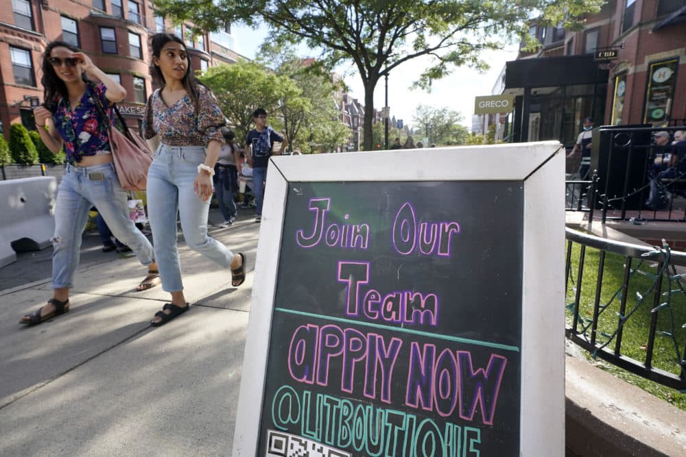 Pedestrians walk past a sign inviting people to apply for employment at a shop in Boston's Newbury Street. (Steven Senne/AP)