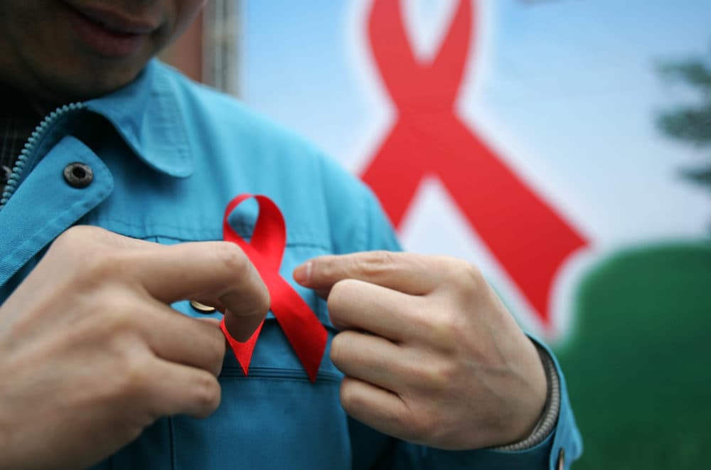A man wears a red ribbon an HIV/AIDS information event. (China Photos/Getty Images)