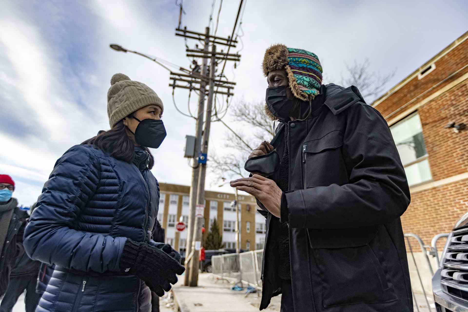 Mayor Michelle Wu speaks with Norris Cowart, who has been in and out of the Southampton Street Shelter, about the current conditions on Atkinson Street. (Jesse Costa/WBUR)
