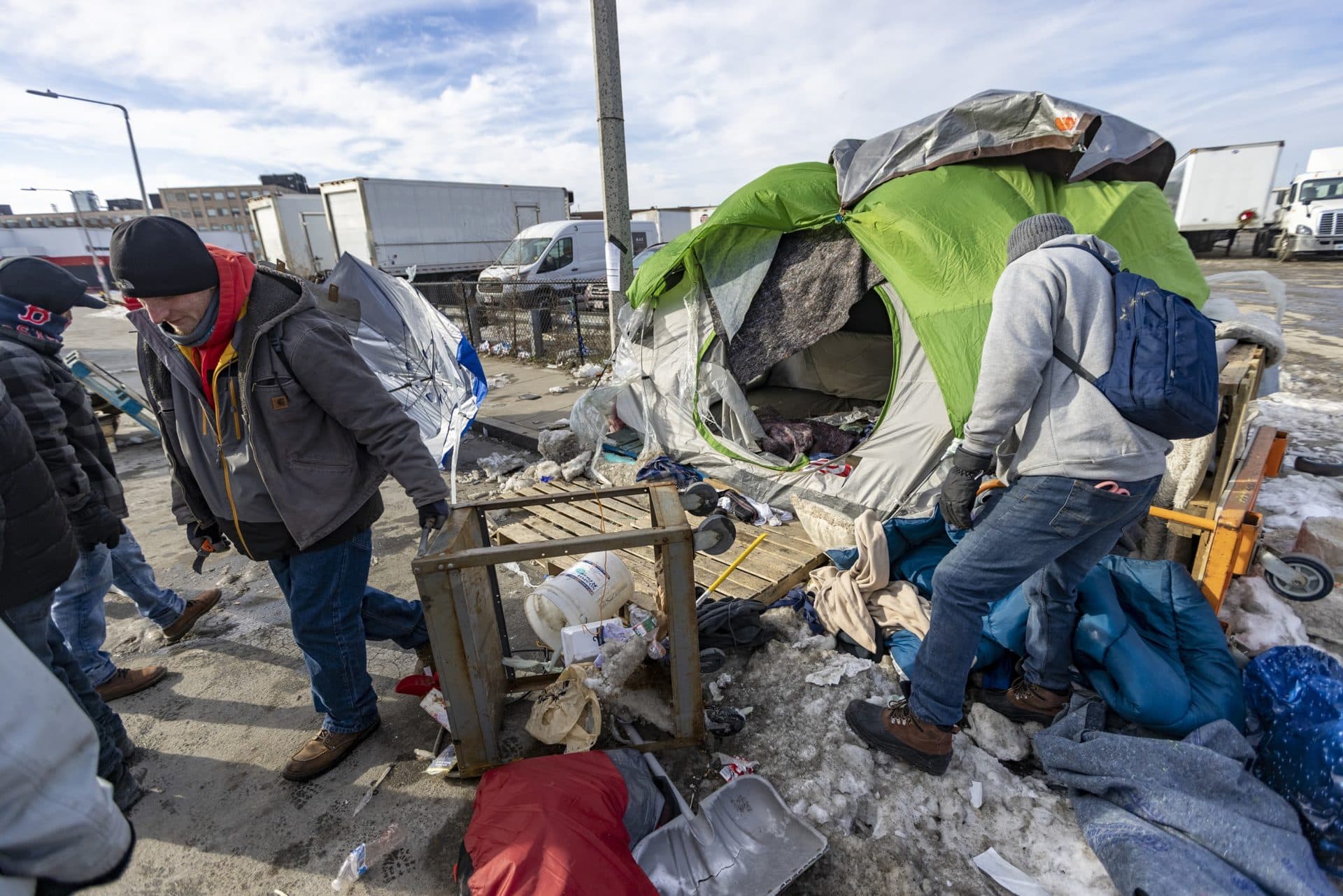 Workers dismantle a homeless tent dwelling at the Newmarket Triangle. (Jesse Costa/WBUR)