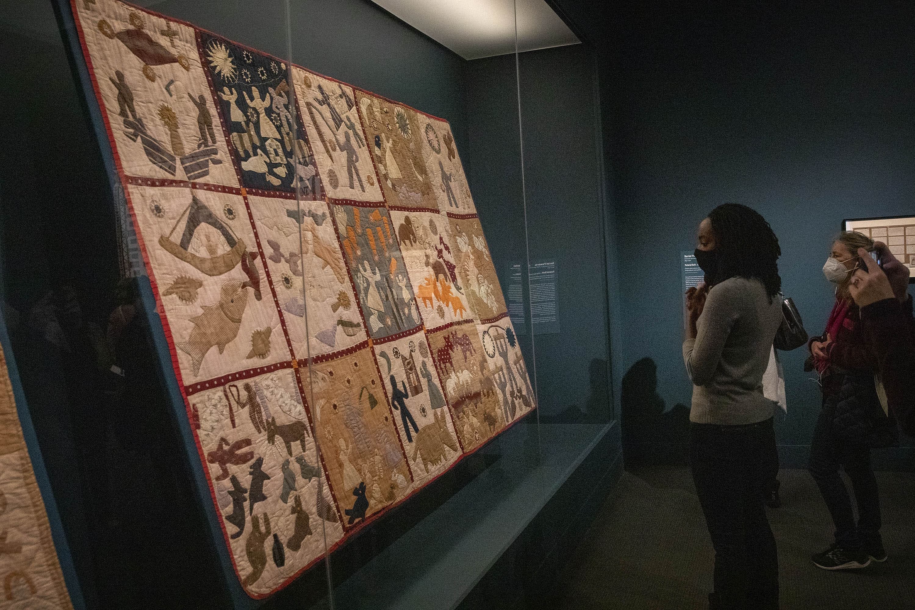 Alyse Minter, a descendent of Harriet Powers, contemplates Powers' Pictorial Quilt on display in the MFA's exhibit "Fabric of a Nation: American Quilt Stories." (Robin Lubbock/WBUR)