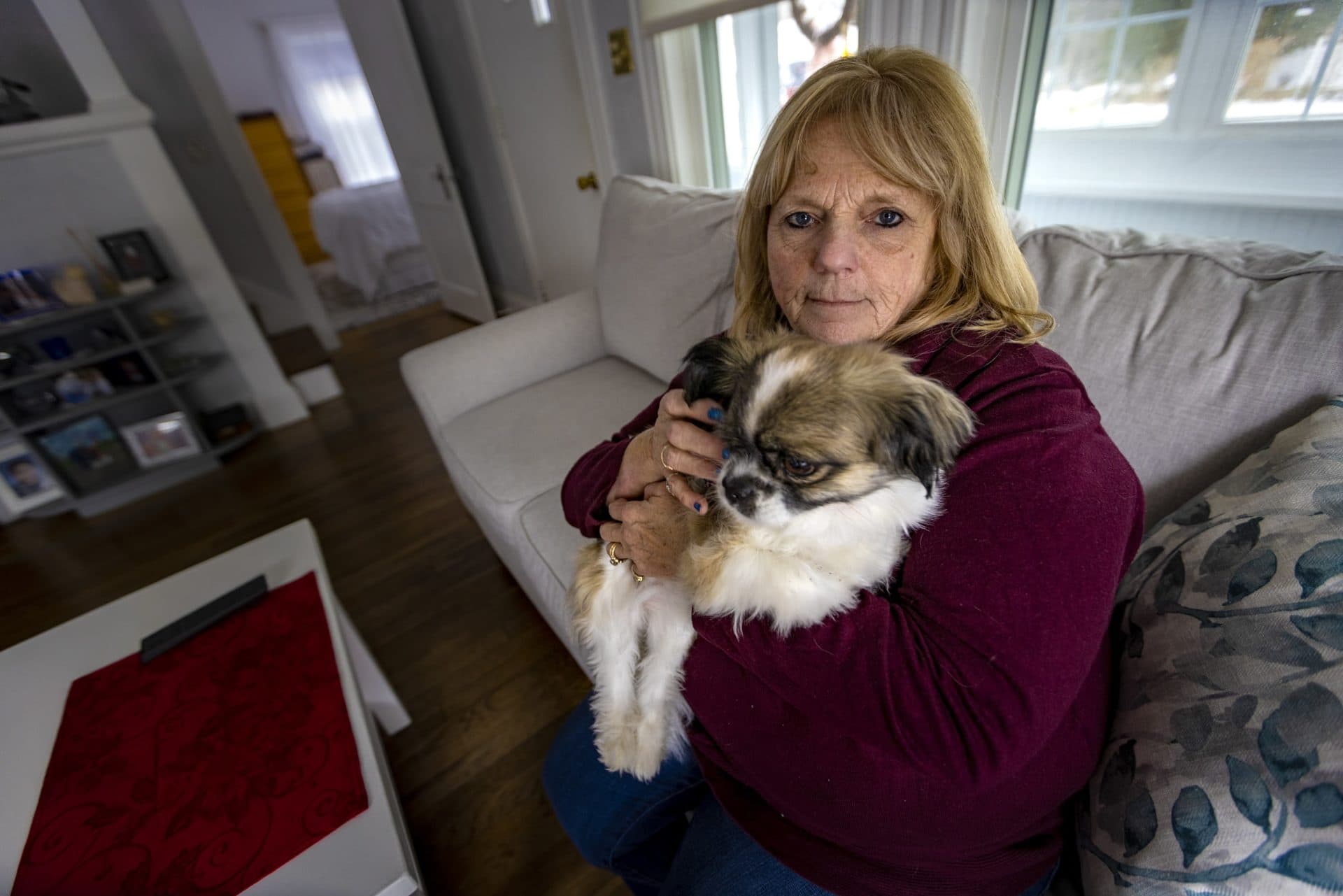 Patti Parent holding her dog Roxie at her home.  (Jesse Costa/WBUR)