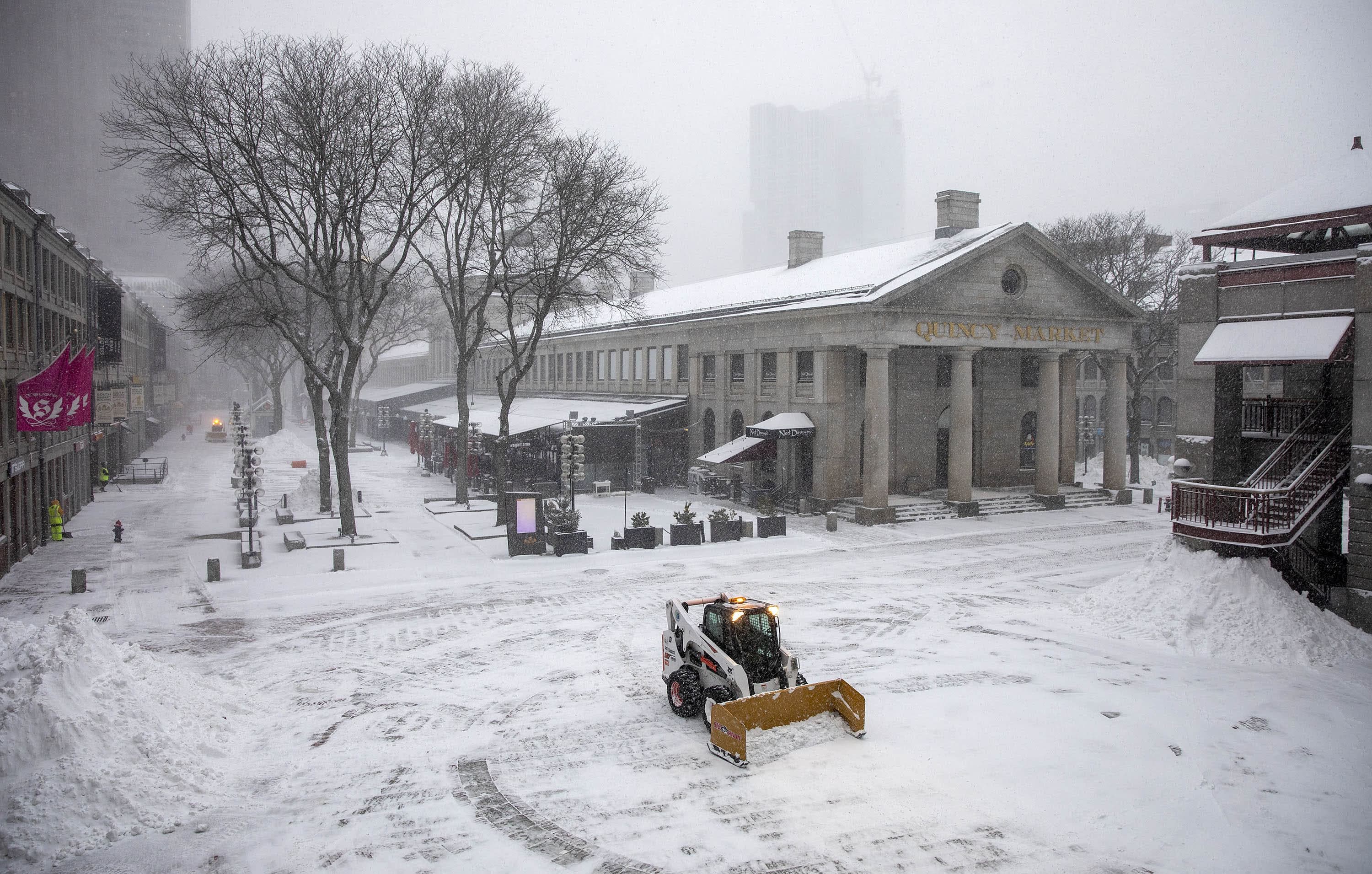A snow plow clears snow from around Quincy Market early in the storm. (Robin Lubbock/WBUR)