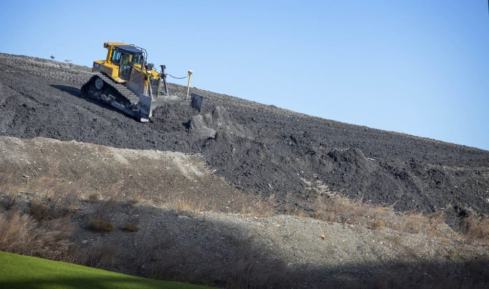 A bulldozer levels ash on a mound beside Covanta's Haverhill waste facility that incinerates trash and generates electricity. (Robin Lubbock/WBUR)