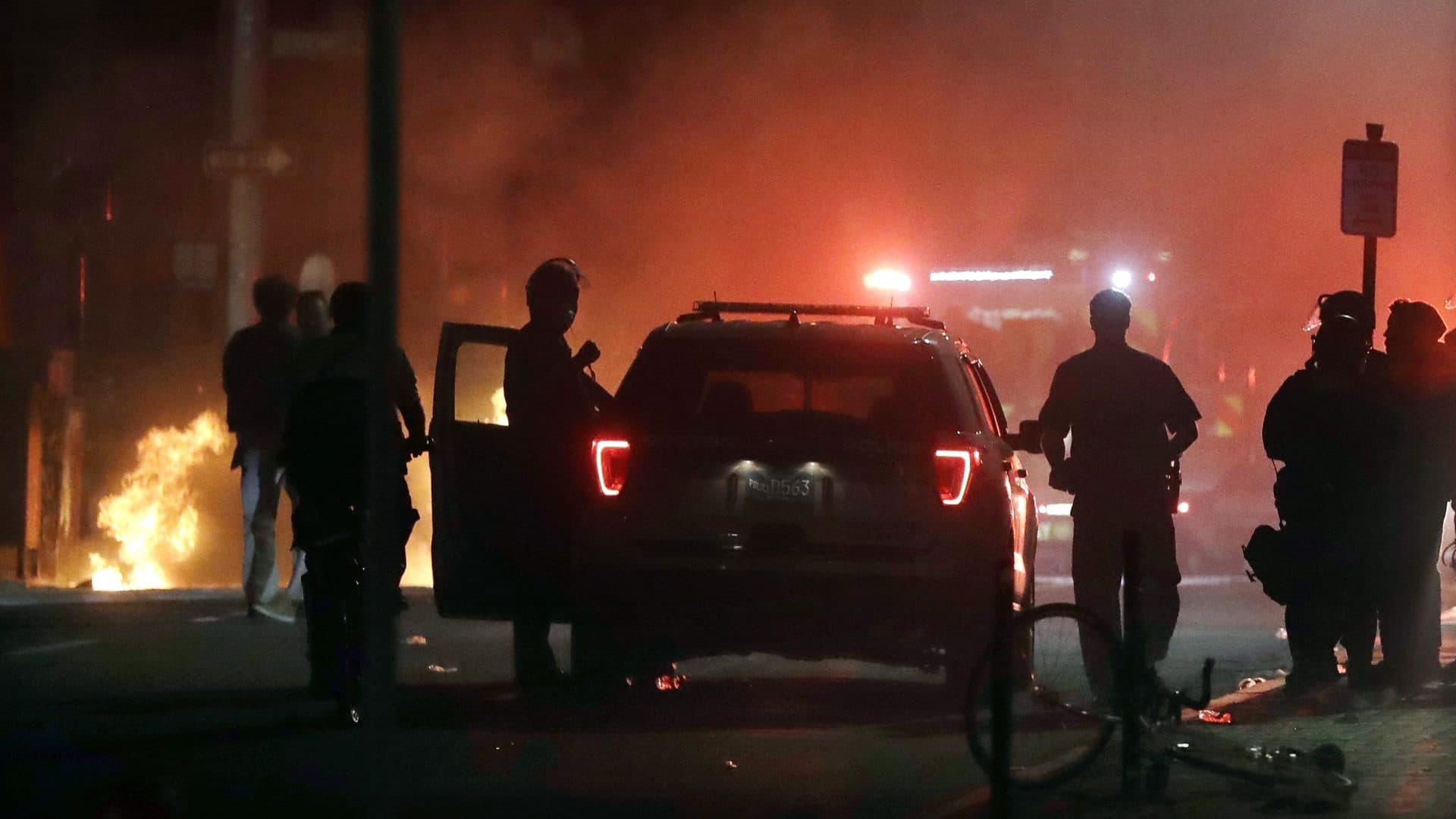 A police car burns, left, after being set on fire in Boston May 31, 2020, following a protest of the death of George Floyd, who died after being restrained by Minneapolis police officers on May 25. (Steven Senne/AP)
