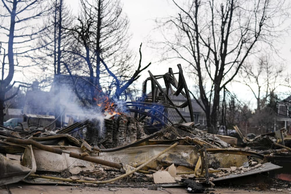 A fire still burns in a home destroyed by the Marshall Wildfire in Louisville, Colo., on Dec. 31, 2021. (Jack Dempsey/AP)