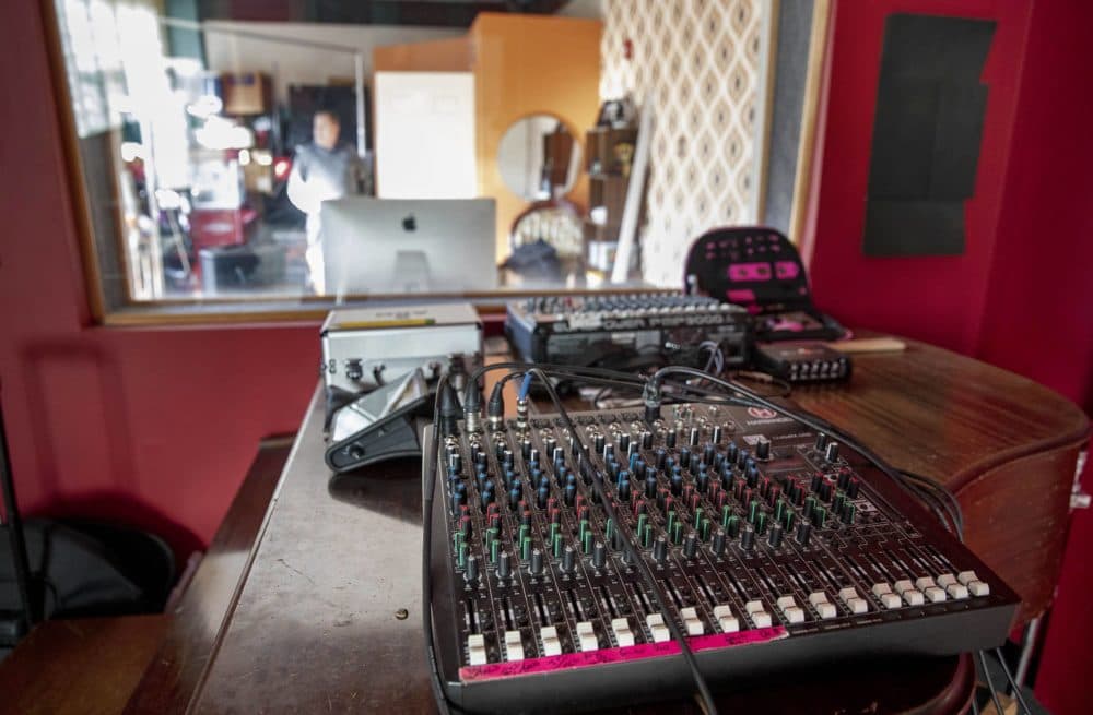 A mixing desk sits above a piano in one of the Brighton Sound Museum's studios.  (Robin Lubbock/WBUR)