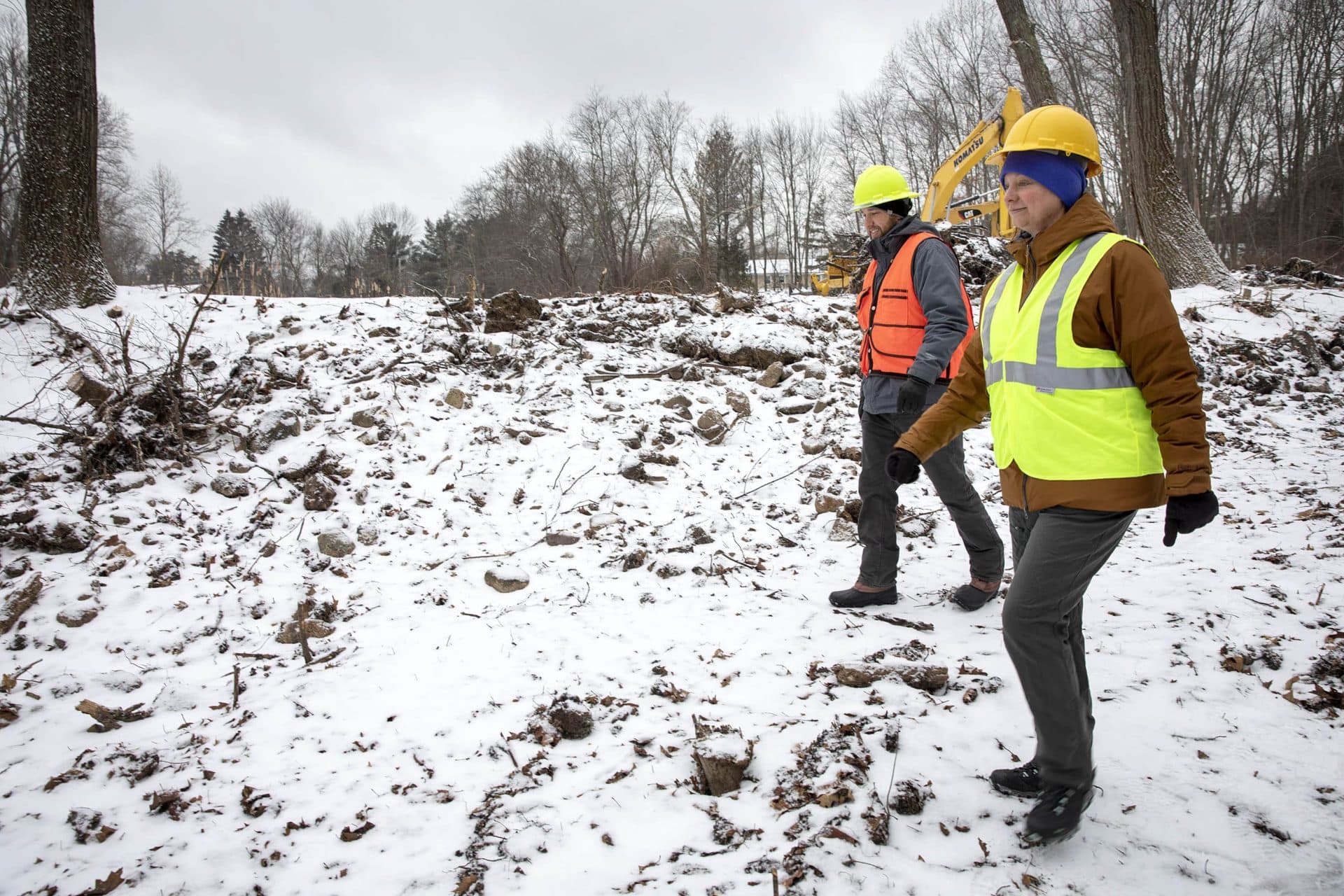 Project Manager Chris Hirsch walks along the berm beside the dam on Traphole Brook with Beth Lambert, director of the Mass. Division of Ecological Restoration. (Robin Lubbock/WBUR)