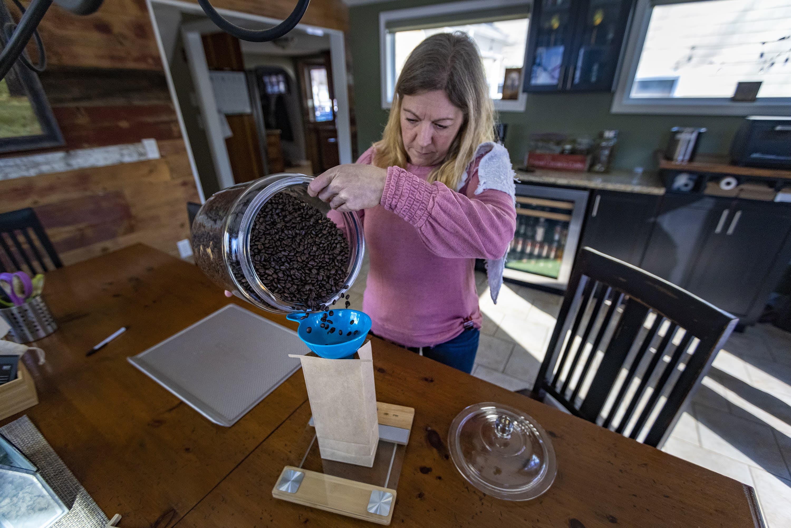 Amy Smith vierte café recién tostado en una bolsa en el negocio de su casa, My Coffeesmiths, en Pembroke. (Jesse Costa/WBUR)