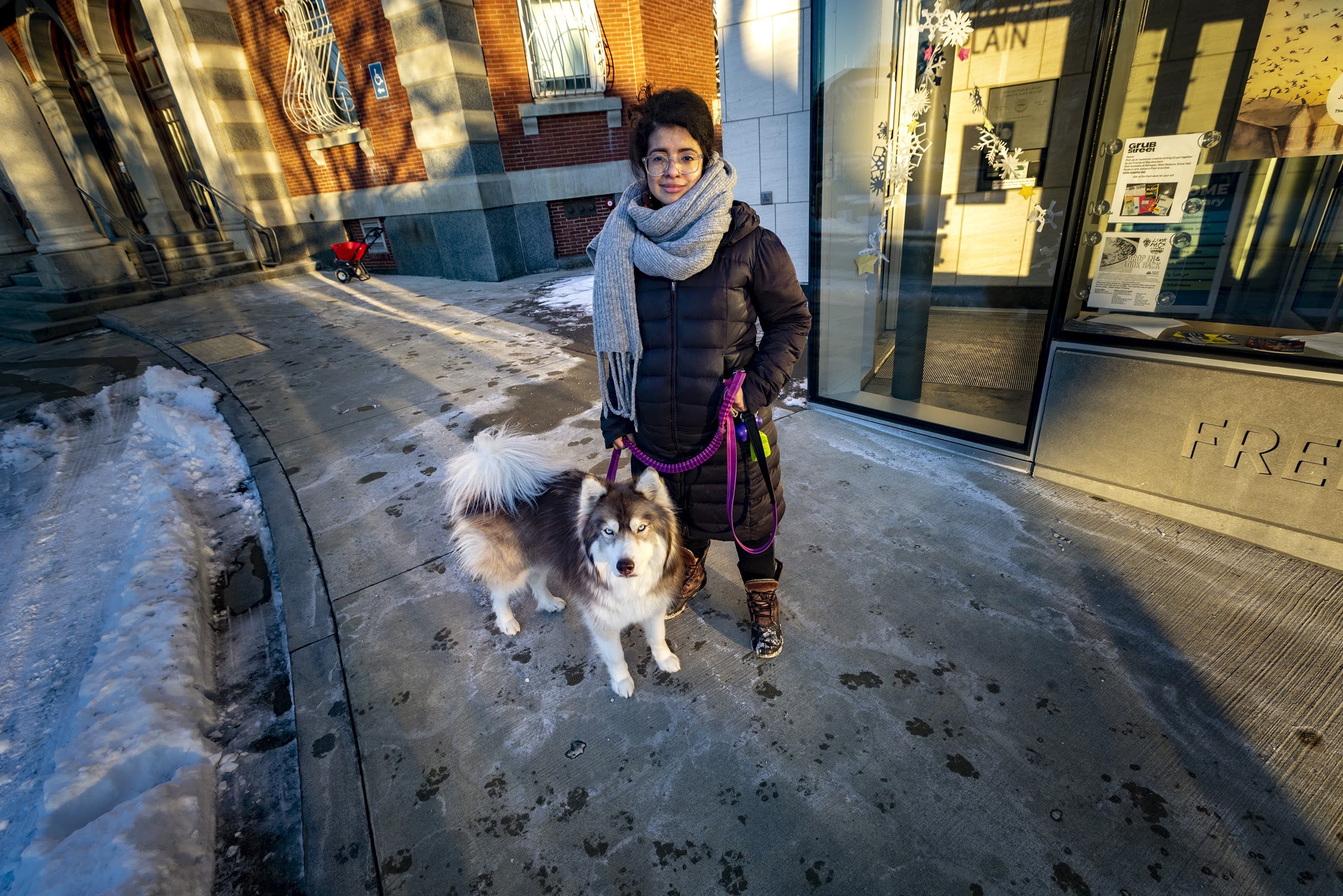 Tatiana Saenz con su perro fuera de la sucursal de Jamaica Plain de la Biblioteca Pública de Boston. (Jesse Coista/WBUR)
