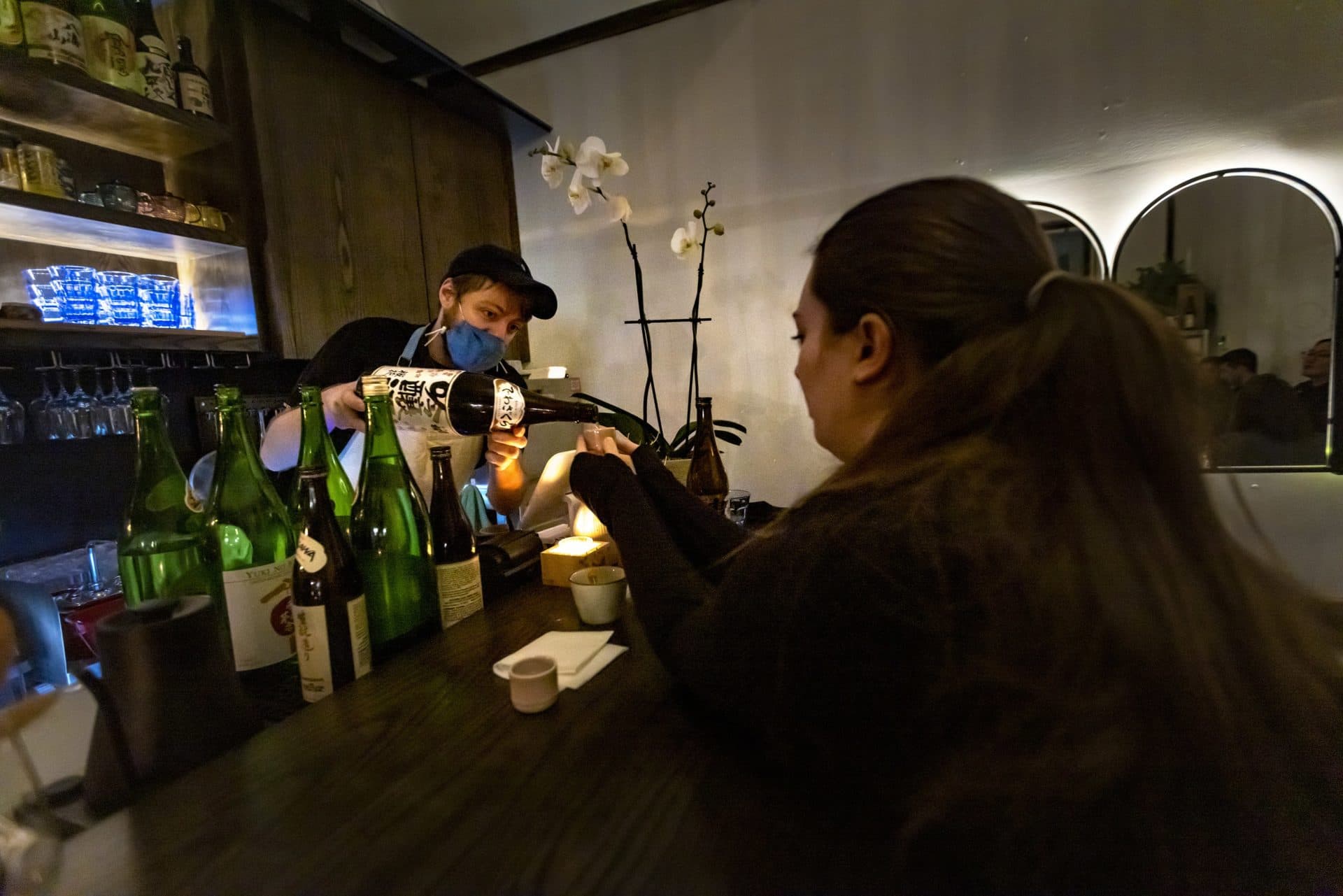 “Sake Steve” Connolly serves a patron from behind the bar at The Koji Club. (Jesse Costa/WBUR)